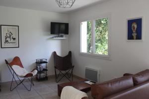 a living room with a couch and chairs at Gîtes L'Escargot Bleu in Oloron-Sainte-Marie