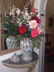a vase with flowers on a shelf in front of a mirror at Eastmount Hall Hotel in Shanklin