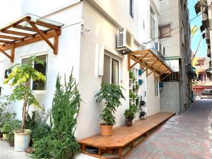 a wooden bench in front of a building with plants at 小巷旺宅 X 旺福 in Tainan