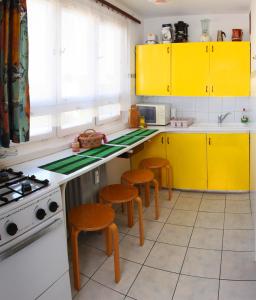 a kitchen with yellow cabinets and stools at Óbuda Apartments in Budapest