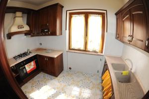 Una pequeña cocina con estufa y ventana. en Da Zio Antonio, en Agerola
