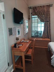 a room with a desk and a bed and a window at Villa Beryl Guesthouse in Vryheid
