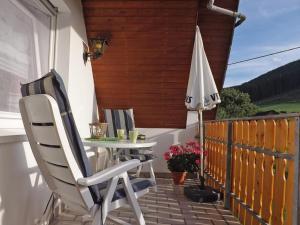 eine Terrasse mit einem Tisch und einem Sonnenschirm in der Unterkunft Ferienwohnung Wallensiepen in Schmallenberg