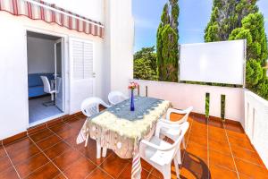 a table and chairs on the balcony of a house at Apartments Ankica in Novalja