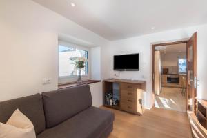 a living room with a couch and a flat screen tv at Apartment Justine Wurdengeja in Selva di Val Gardena