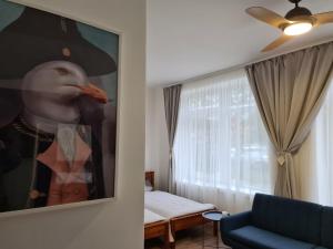a living room with a painting of a man with a hat at Blue Seagull Taikos 13-28 in Nida