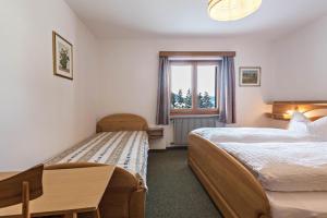 a bedroom with two beds and a window at Große Gartenwohnung Haus Forelle in Selva di Val Gardena