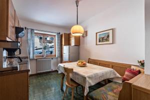 a kitchen with a table with a bowl of fruit on it at Große Gartenwohnung Haus Forelle in Selva di Val Gardena