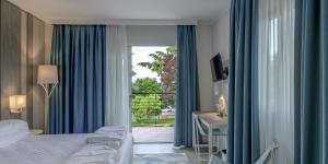 een slaapkamer met een bed, een bureau en een raam bij Hotel Europa in Garda