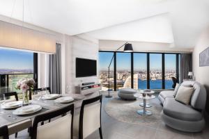 a living room with a dining table and a television at Oakwood Suites Yokohama in Yokohama