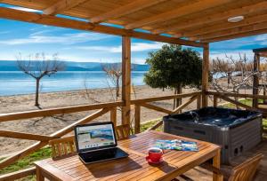 a wooden table with a laptop computer on a table on the beach at Mobile Homes Camp Galeb in Omiš
