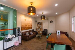 a living room with a table and a couch at Fenix in Pathum Thani