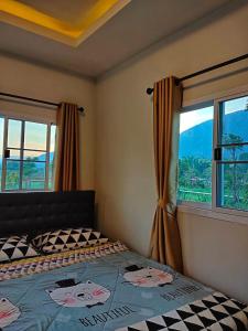 a bedroom with a bed and a window at Ban Thung Talay Mok Chiangdao in Chiang Dao