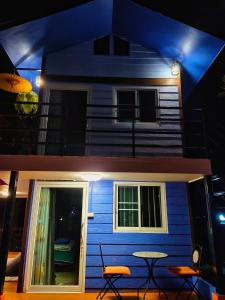une maison bleue avec une table en face dans l'établissement Ban Thung Talay Mok Chiangdao, à Chiang Dao