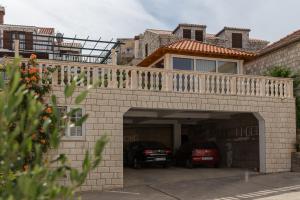 a house with a garage with cars parked in it at Apartments Orange Tree in Cavtat