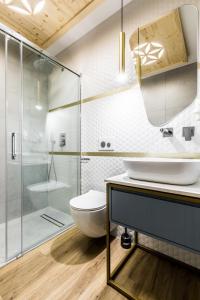 een badkamer met een toilet en een glazen douche bij Aparthotel Prestige in Zakopane