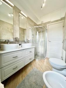 uma casa de banho com 2 lavatórios e um chuveiro em MilanHolidays em Milão