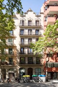 Chic Apartments Barcelona في برشلونة: مبنى طويل وبه سيارات متوقفة أمامه