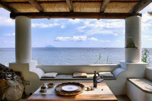 Una habitación con mesa y vistas al océano en Le case di Eolo - Santa Marina Salina, en Santa Marina Salina