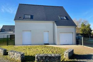 un garaje blanco con dos puertas y un techo en Belle maison neuve à 10 minutes de Chambray-lès-Tours, en Esvres