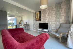sala de estar con sofá rojo y TV en Belle maison neuve à 10 minutes de Chambray-lès-Tours, en Esvres