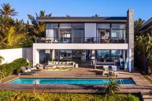 a house with a swimming pool in front of it at Dolphin Coast YOLO Spaces - Beach House Villa in Ballito