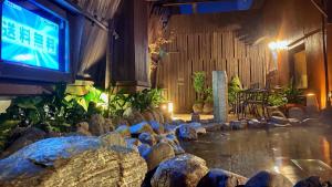 um quarto com uma lagoa com pedras e uma televisão em Dormy Inn Akihabara em Tóquio