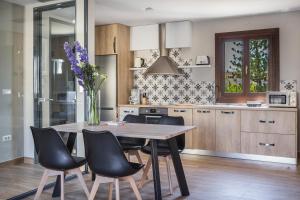 uma cozinha com uma mesa de madeira e cadeiras pretas em Suite Royal em Argostoli