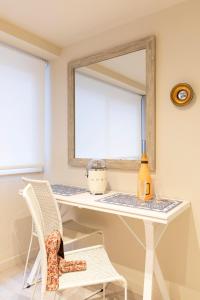 Chic Apartments Barcelona في برشلونة: طاولة تزيين مع كرسي ومرآة