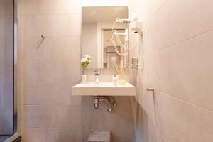 Chic Apartments Barcelona في برشلونة: حمام مع حوض ومرآة