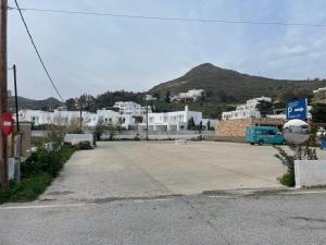 a parking lot with a blue bus in front of a town at Patmos Villas in Grikos