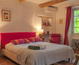 a bedroom with a large bed with a red headboard at Montjoia in LʼIsle-sur-la-Sorgue +75 photos