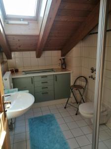 ein Bad mit einem Waschbecken, einem WC und einem Fenster in der Unterkunft Ferienwohnung Kronshage in Reit im Winkl