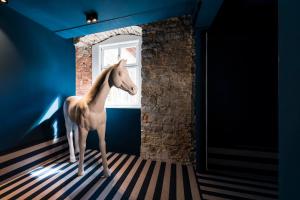 un caballo de juguete parado en una habitación con ventana en Romantik Hotel Zur Schwane, en Volkach