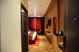 um quarto de hotel com uma cama e uma cortina vermelha em B.O.B HOTEL SIGNATURE em Cao Lãnh