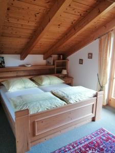 ein großes Bett in einem Zimmer mit Holzdecke in der Unterkunft Ferienwohnung Kronshage in Reit im Winkl