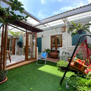 un jardín con un columpio y un parque infantil en The Little Cottage 47 en Bangkok