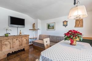 sala de estar con sofá y mesa en Panoramico Haus Forelle en Selva di Val Gardena