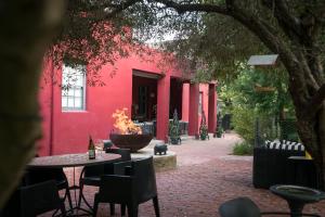 a red building with a table and chairs in front of it at Ruby Rose in Riebeek-Wes