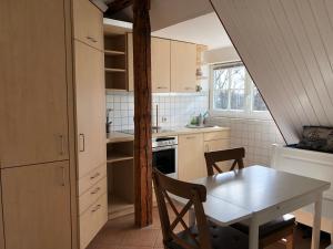 a kitchen with a table and a table and a dining room at Ankerplatz Warnemünde - Direkte Strandnähe mit Leuchtturmblick in Warnemünde