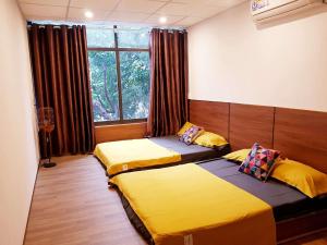 two beds in a room with a window at Codohomestay Garden in Hue