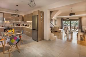 Grand View Maisonette في أرغوستولي: مطبخ وغرفة معيشة مع طاولة وكراسي