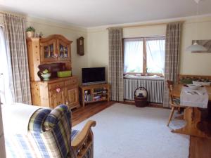 a living room with a bed and a tv and a couch at Haus Schmauß - Chiemgau Karte in Inzell