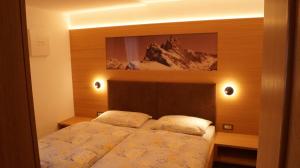 a bedroom with a bed with a picture on the wall at Apartments Salieta in Santa Cristina in Val Gardena