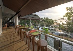 a patio area with tables and chairs and a balcony at Andamantra Resort and Villa Phuket - SHA Extra Plus in Patong Beach