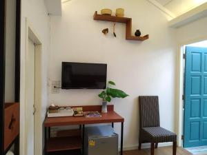 a room with a desk with a tv on a wall at The Little Cottage 47 in Bangkok