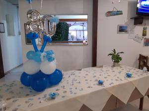 une table avec une pièce centrale pour ballons bleu et blanc dans l'établissement Agriturismo Terra dei Profumi, à Otrante