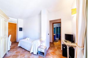 a bedroom with a bed and a television in it at Hotel il Faro di Molara in Porto San Paolo