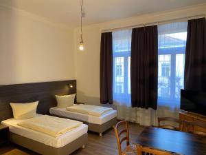 Zimmer mit 2 Betten, einem Tisch und einem TV in der Unterkunft Ferienwohnungen Neumann in Bamberg