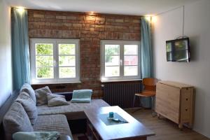 ein Wohnzimmer mit Sofa und Ziegelwand in der Unterkunft Kleine Schwalbe in Kabelhorst